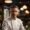 A man in a chef's uniform standing in front of a bar.